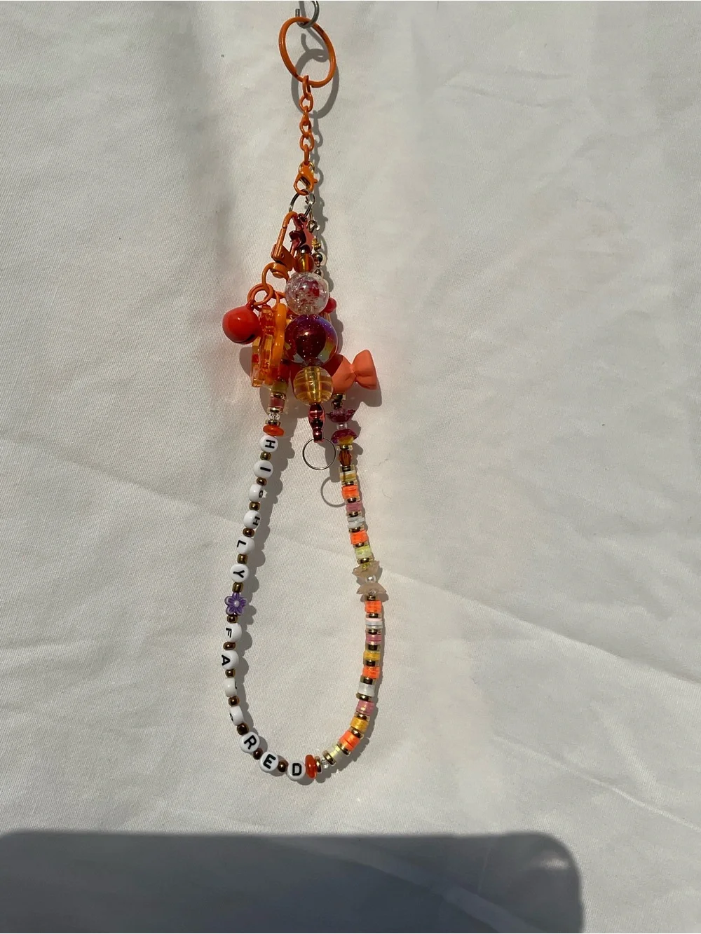 Beaded Orange Keychain with beaded bar. “Highly Favored”